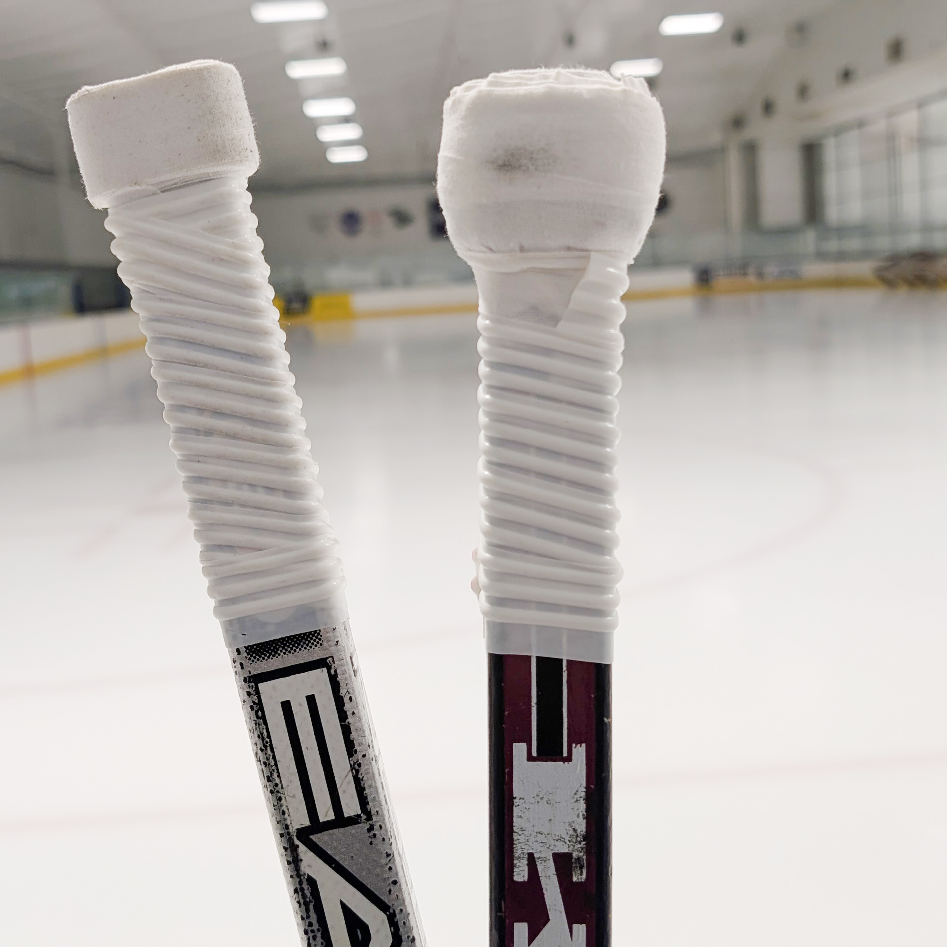 Hockey stick handles covered in white grip tape. 